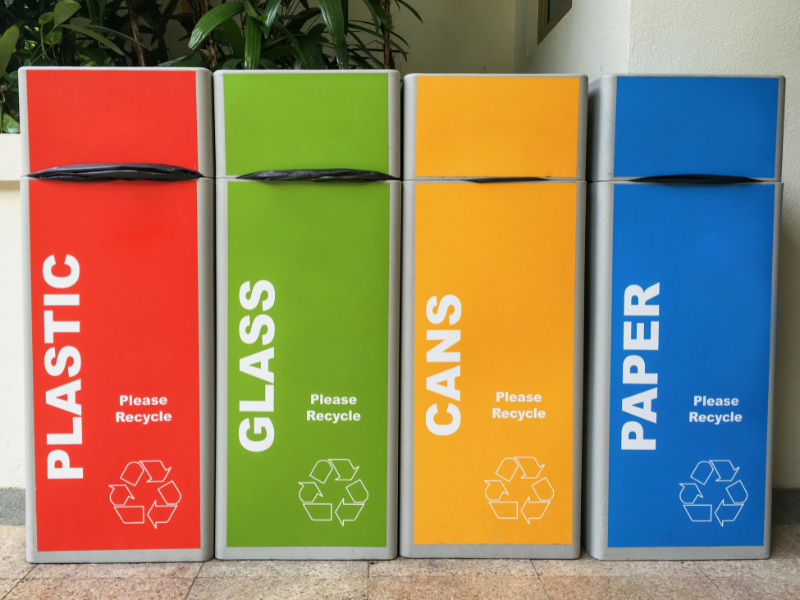 Brightly coloured recycling bins for plastic, glass, cans and paper